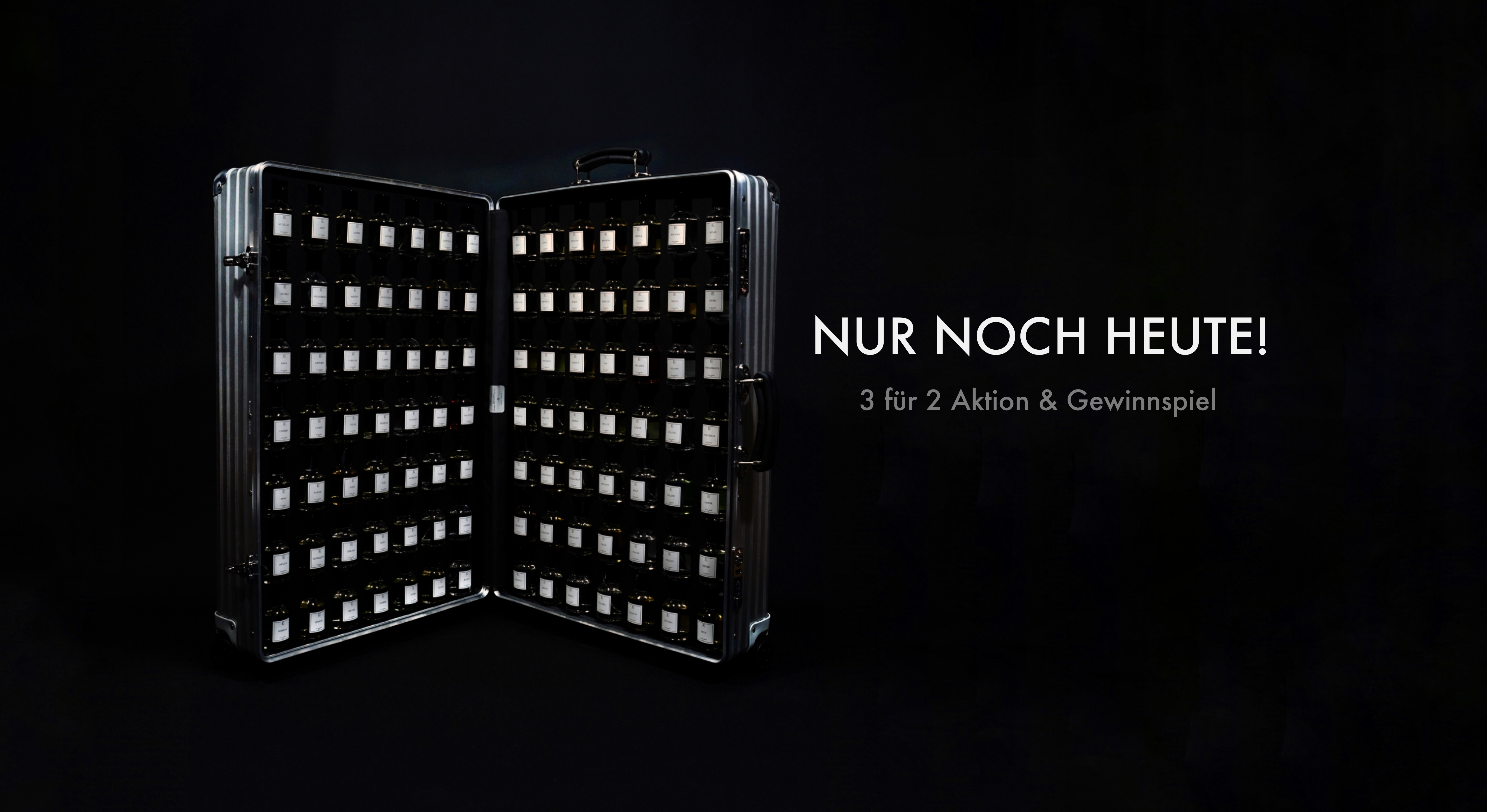 Ein silberner, geöffneter Koffer mit vielen kleinen, gleichartigen Flaschen mit weißen Etiketten ist links zu sehen. Rechts steht auf schwarzem Hintergrund in großen Buchstaben "NUR NOCH HEUTE! 3 für 2 Aktion & Gewinnspiel". Die Fläschchen sind in Reihen im Koffer angeordnet. Die Szene wirkt exklusiv, edel und auf ein besonderes Angebot ausgerichtet.